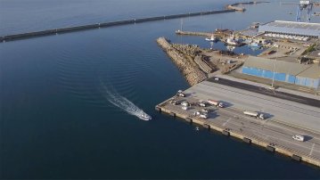 Vue aérienne du quai H du port de Sète en chantier, avec engins de construction en activité.