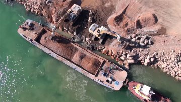 Chargement de matériaux sur une barge par pelleteuses depuis la berge du port de Sète – vidéo de chantier produite par l’Agence Satellite.